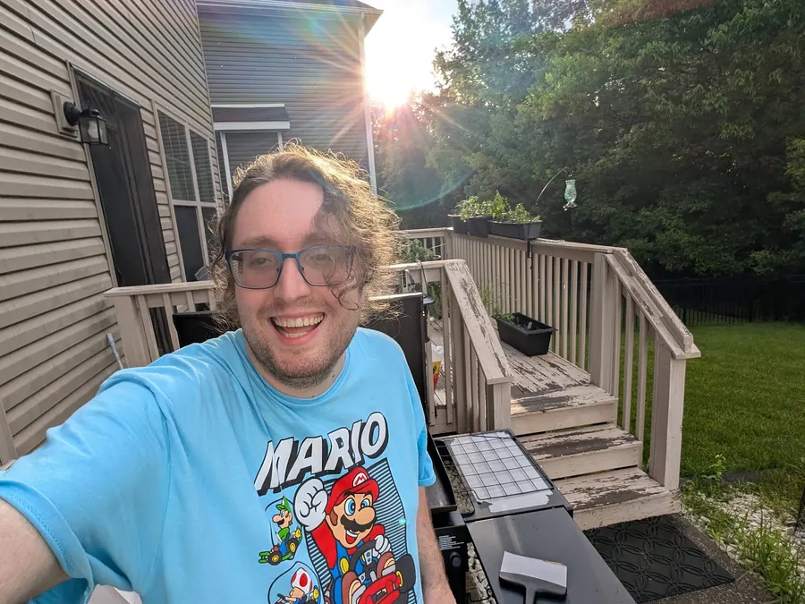 Sean Talbot smiling beside the grill on his deck