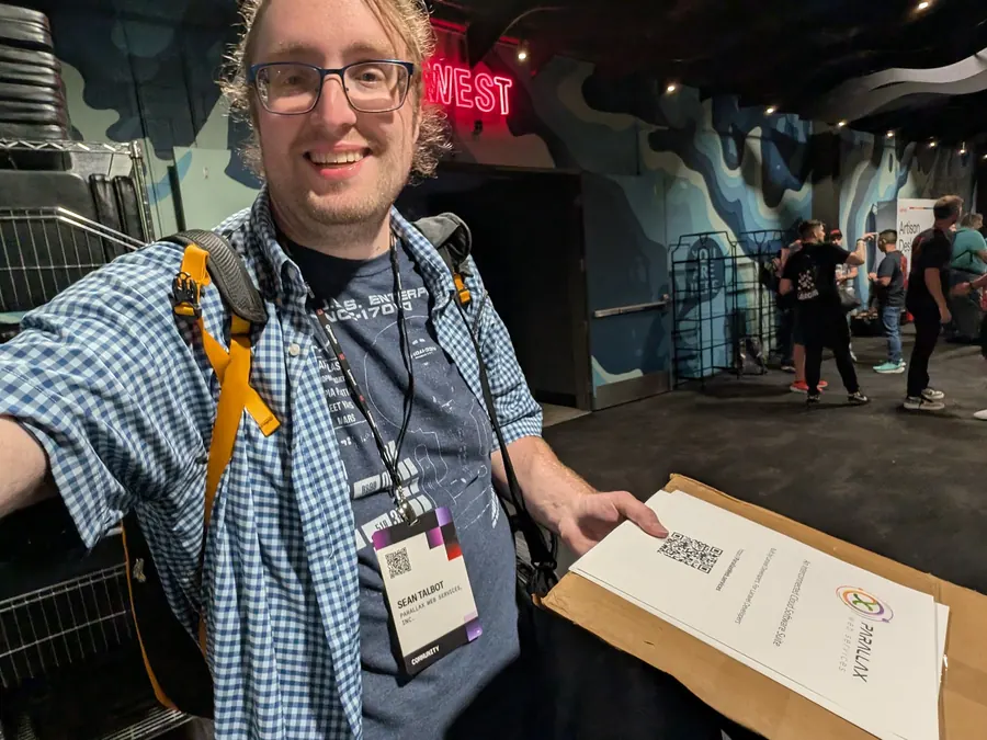 Sean Talbot smiling at Laracon with conference materials in hand
